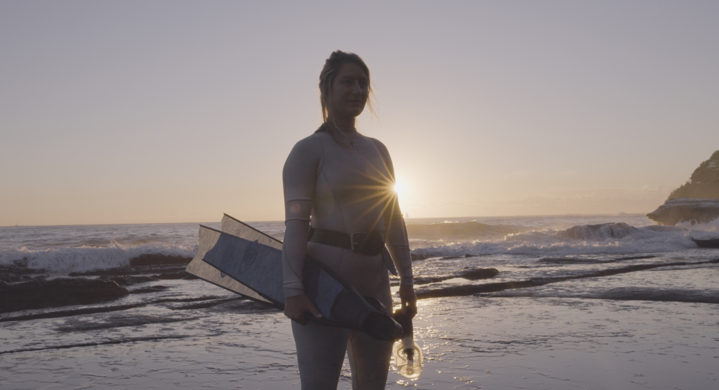 Two freedivers sharing a relaxed moment by the water.